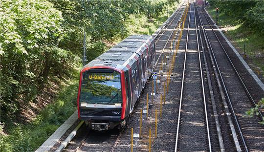 Eine Bahn mit der Aufschrift "U-Bahn 100" fährt während eines Pressetermins der Hamburger Hochbahn zur ersten Fahrt mit automatisierter U-Bahn auf der Teststrecke in Hamburg-Farmsen-Berne. Alle 100 Sekunden soll eine U-Bahn in Zukunft Hamburgerinnen und Hamburger von A nach B bringen. Das von der Hochbahn gestartete Projekt U-Bahn 100 hat mit ersten Testfahrten einen weiteren Schritt in Richtung Mobilitätswende gemacht. Foto: Georg Wendt/dpa