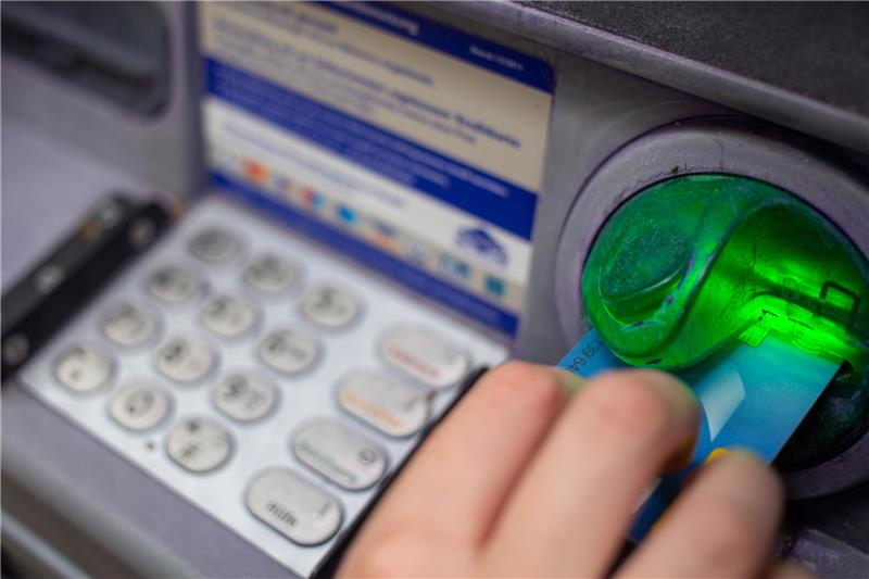 Eine Bankkundin steckt ihre Girokarte in einen Geldautomaten. Banken und Sparkassen ziehen die Gebührenschraube weiter an. Foto: Fernando Gutierrez-Juarez/dpa-Zentralbild/dpa