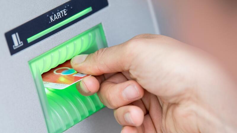 Basiskonten in Deutschland besonders teuer Eine Bankkundin steckt ihre Girokarte in einen Geldautomaten: Seit 2016 hat jeder Bürger in Deutschland Anspruch auf ein Girokonto.