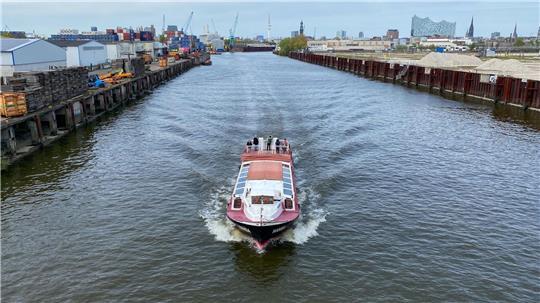 Eine Barkasse fährt auf einem Kanal im Hafen unter der Argentinienbrücke durch. (Archivbild) 