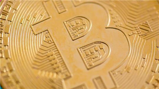 Eine Bitcoin-Münze liegt auf einem Tisch. (Symbolbild)