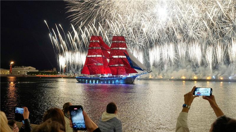 Eine Brigg, ein zweimastiges Segelschiff mit Rahsegeln an beiden Masten, fährt mit scharlachroten Segeln auf der Newa während der „Scarlet Sails“-Feierlichkeiten. Die „Scarlet Sails“ („Purpurne Segel“) sind ein Fest, mit dem die russische Stadt St. Petersburg jedes Jahr die Schulabgänger feiert.