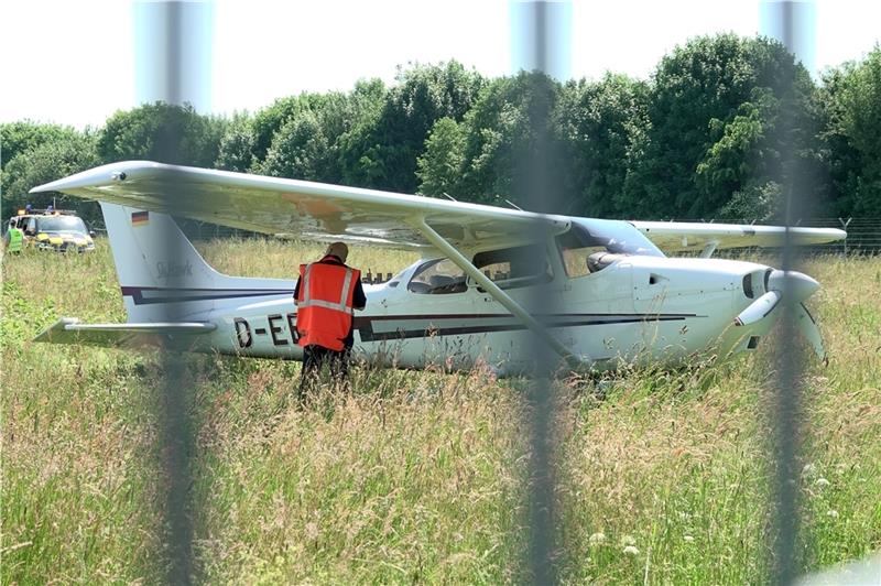 Eine Cessna steht auf dem Airport Hamburg hinter einem Zaun im Gras. Das Kleinflugzeug war von der Startbahn abgekommen und im Gras liegengeblieben. Foto: Bodo Marks/dpa