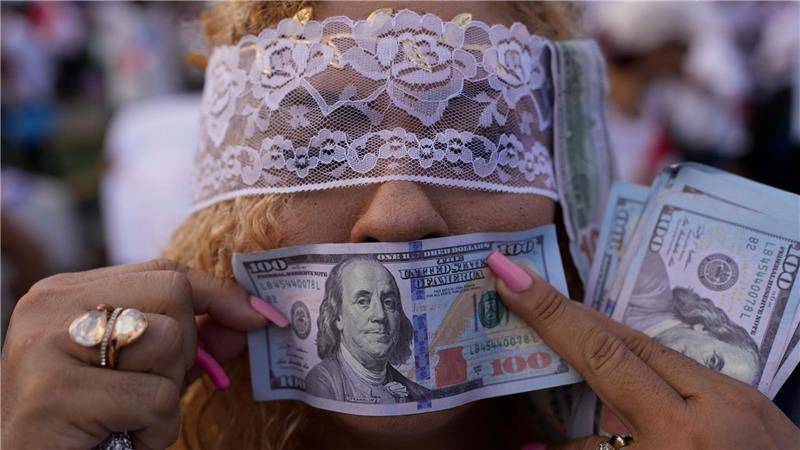 Eine Demonstrantin hält während einer Demonstration in Panama-Stadt gegen die Politik von Panamas Präsident Mulino eine falsche US-Banknote vor ihren Mund.
