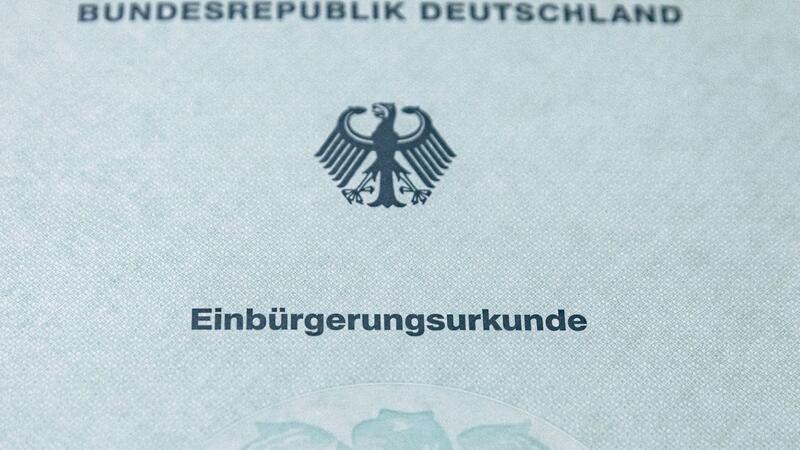 In Hamburg sind 2023 mehr Menschen eingebürgert worden Eine Einbürgerungsurkunde liegt bei einem Festakt im Hamburger Rathaus auf einem Tisch.