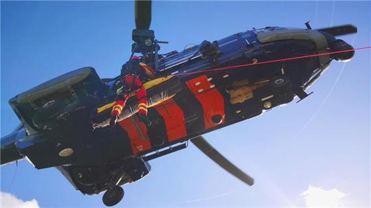Eine Einsatzkraft begleitet den „Verletzten“ beim Aufwinschen in den Hubschrauber der Bundespolizei.