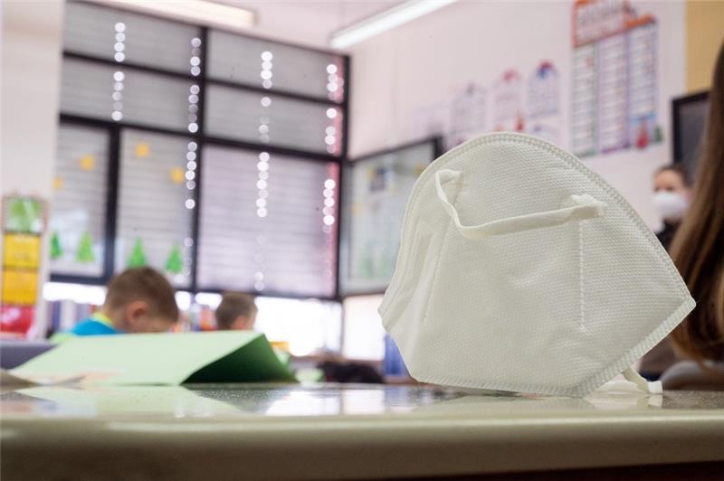 Eine FFP2-Maske liegt in einer ersten Klasse an einer Grundschule auf einem Tisch.  Foto: Sebastian Gollnow/dpa