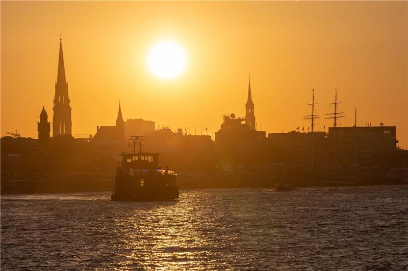 Umweltverbände fordern mehr Kooperation der Häfen Eine Fähre fährt am Morgen bei Sonnenaufgang im Hamburger Hafen.