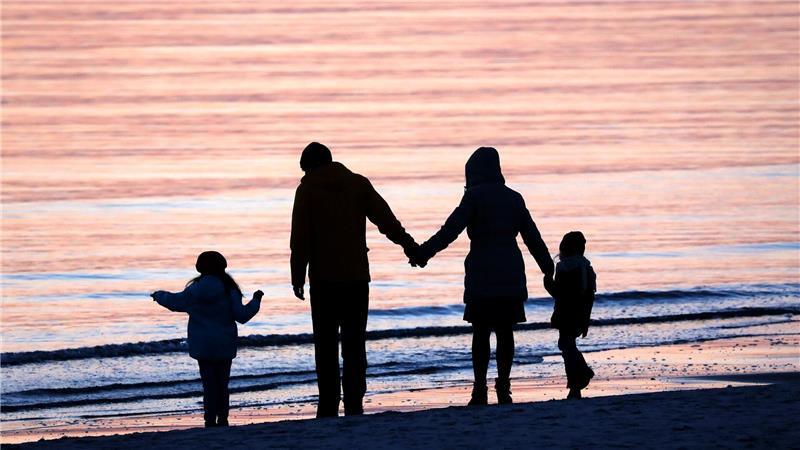 Eine Familie mit zwei Kindern am Strand. (Symbolbild)