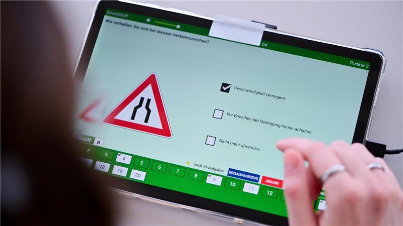 Kostenbremse geplant: Was macht den Führerschein in Deutschland so teuer? Eine Frau beantwortet im Dekra Standort Berlin-Hohenschönhausen eine Frage der theoretischen Prüfung des Führerscheins. (Gestellte Szene)