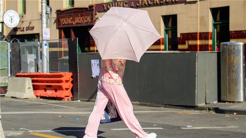 Eine Frau benutzt einen Regenschirm, um sich vor der Sonne zu schützen.