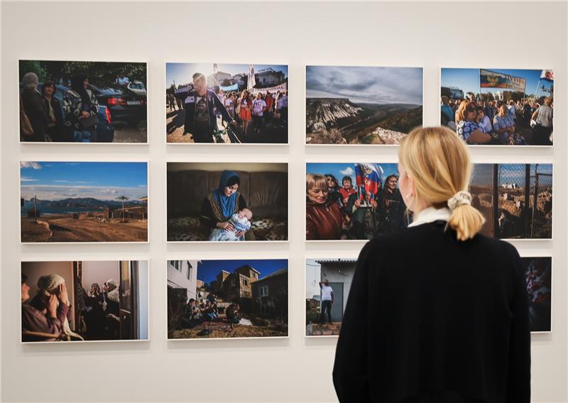 Ukrainische Fotografien zeigen den Alltag des Krieges Eine Frau betrachtet Aufnahmen der ukrainischen Fotografin Alina Smutko aus der Serie „New Hybrid Deportation“ (2016-2019) in der Ausstellung „The new Abnormal“ im Phoxxi, dem temporären Haus der Photographie der Deichtorhallen Hamburg. Foto: Christian Charisius/dpa