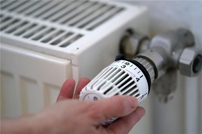 Deutschlands größter Wohnungskonzern Vonovia will Heizungstemperatur nachts absenken Eine Frau dreht an einem Heizungsthermostat.