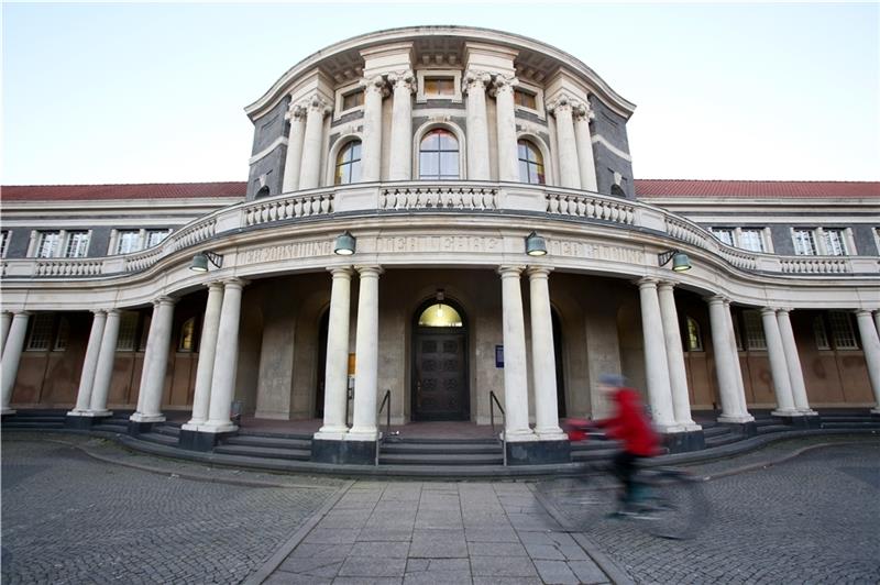 Uni Hamburg: Studierende besetzen einen Hörsaal Eine Frau fährt mit einem Fahrrad an dem Hauptgebäude der Universität Hamburg vorbei. Erst zum Wintersemester können Studenten wieder an ihre Hochschulen zurückkehren. Foto: Marks/dpa