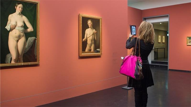 Eine Frau fotografiert Gemälde in der Kunsthalle Hamburg. 