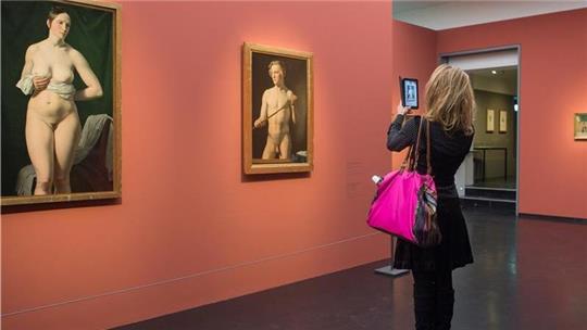 Eine Frau fotografiert Gemälde in der Kunsthalle Hamburg. 