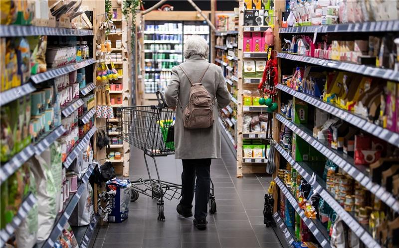 Eine Frau geht mit ihrem Einkaufswagen durch einen Supermarkt. Die Menschen in Deutschland müssen für Lebensmittel in den nächsten Monaten wahrscheinlich noch einmal deutlich mehr bezahlen. Foto: Sven Hoppe/dpa