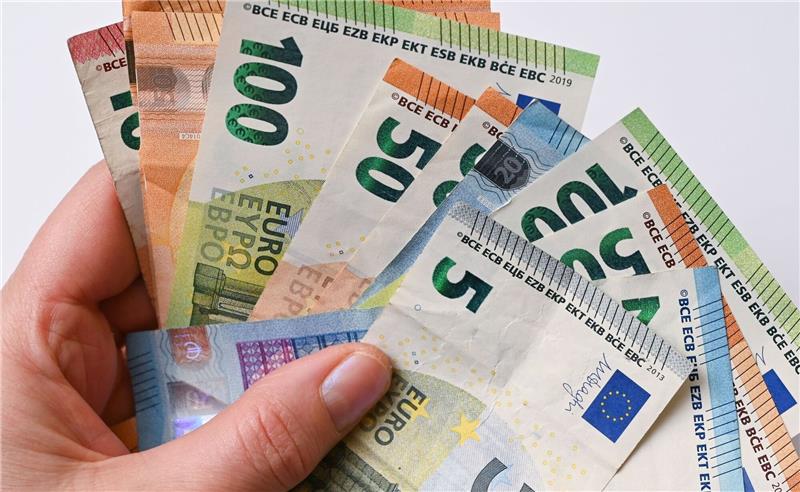 13 Millionen Euro für Sportstätten - Vereine sollten Fördermittel schnell beantragen Eine Frau hält Geldscheine in der Hand.