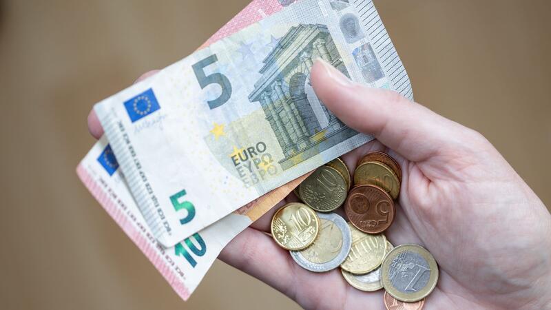 Armut im Norden: bessere Hilfe gefordert Eine Frau hält Geldscheine und Münzen in der Hand.
