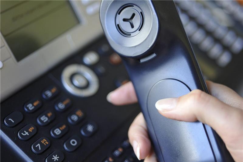 Eine Frau hält den Hörer eines Festnetz-Telefons in der Hand - der Apparat ist seit der Pandemie wieder im Kommen.