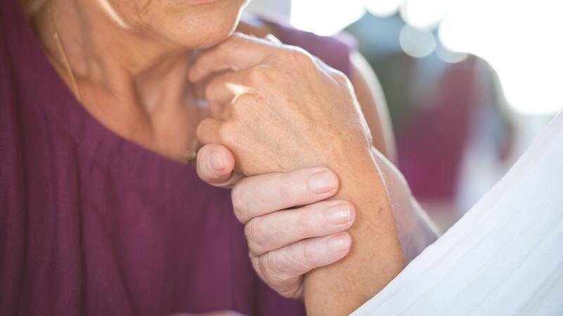 Wie Musik bei Demenz helfen kann Eine Frau hält die Hand ihres an Demenz erkrankten Mannes. (Archivbid
