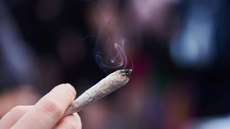 Rund 200 Cannabis-Konsumenten pro Jahr in Hamburger Kliniken Eine Frau hält einen Joint in der Hand.