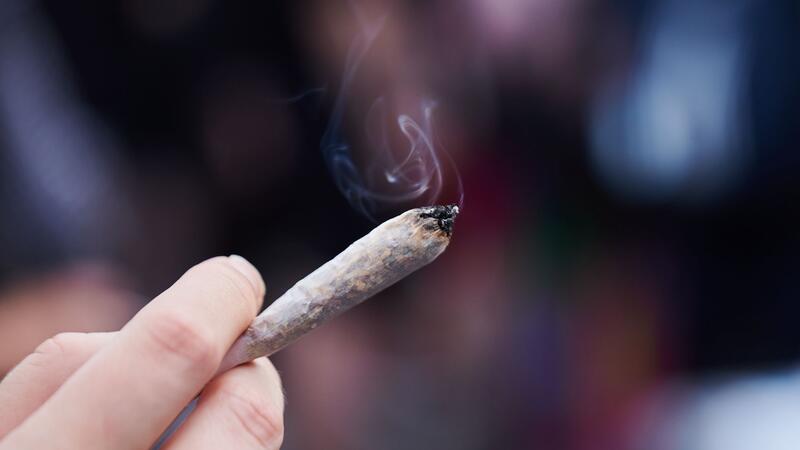 Koalition einig: Cannabis-Legalisierung zum 1. April Eine Frau hält einen Joint in der Hand: Cannabis wird von der Liste der verbotenen Substanzen gestrichen.