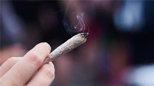 Eine Frau hält einen Joint in der Hand (Symbolbild).