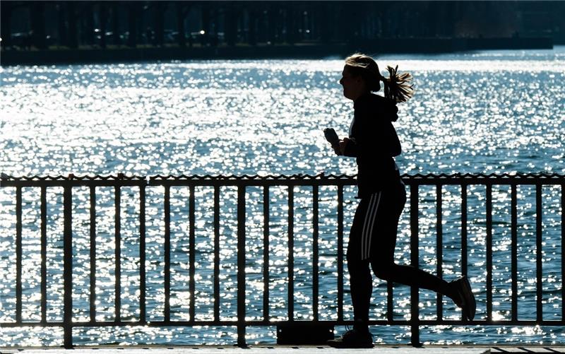 Eine Frau joggt bei Sonnenschein um den Maschsee. Der Erfolg von Neujahrsvorsätzen hängt auch davon ab, wie sie formuliert werden. Foto: Julian Stratenschulte/dpa