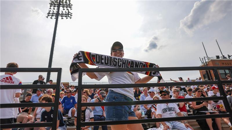 Eine Frau kommt mit Deutschlandschal zur ersten Trainingseinheit der Nationalmannschaft auf das Gelände der Wake Forest University in Winston-Salem.