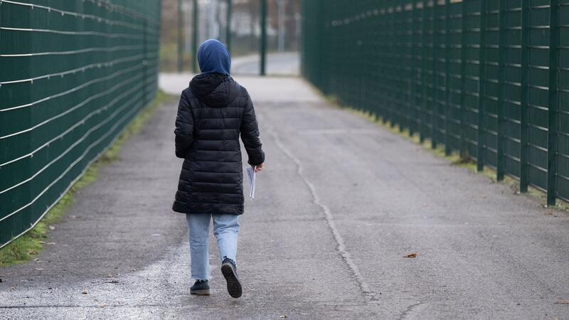 Eine Frau läuft in einer Erstaufnahmeeinrichtung zu ihrer Unterkunft.