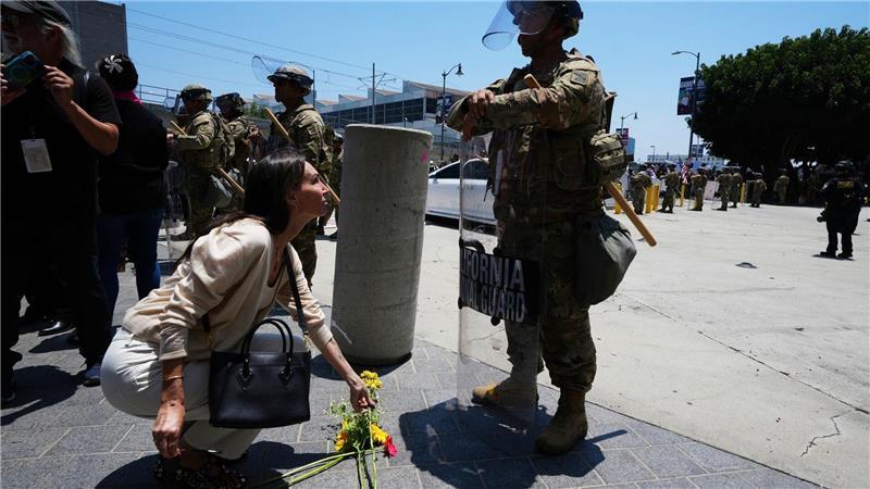 Texas: Gouverneur will Nationalgarde bei Protesten einsetzen Eine Frau legt Blumen vor der Nationalgarde nieder.