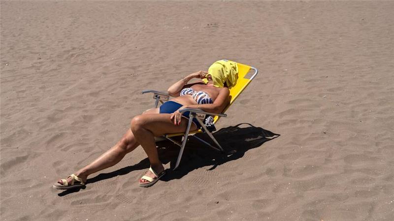 Eine Frau nimmt ein Sonnenbad am Strand Las Toscas in Mar del Plata in Argentinien.