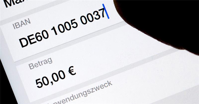 Geld soll binnen Sekunden da sein Eine Frau nutzt auf ihrem Smartphone eine App, um im Online-Banking eine SEPA-Überweisung zu veranlassen (gestellte Szene). Foto: Monika Skolimowska/dpa-Zentralbild/dpa