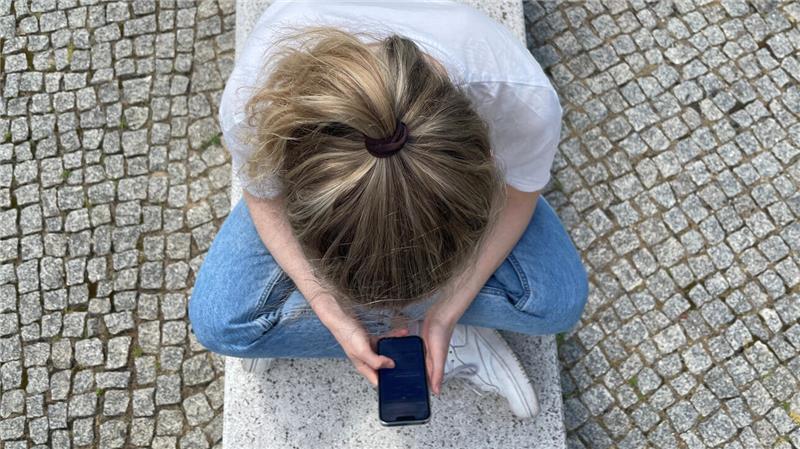 Umfrage: Internet dominiert Freizeit der Deutschen Eine Frau schaut auf ihr Smartphone.