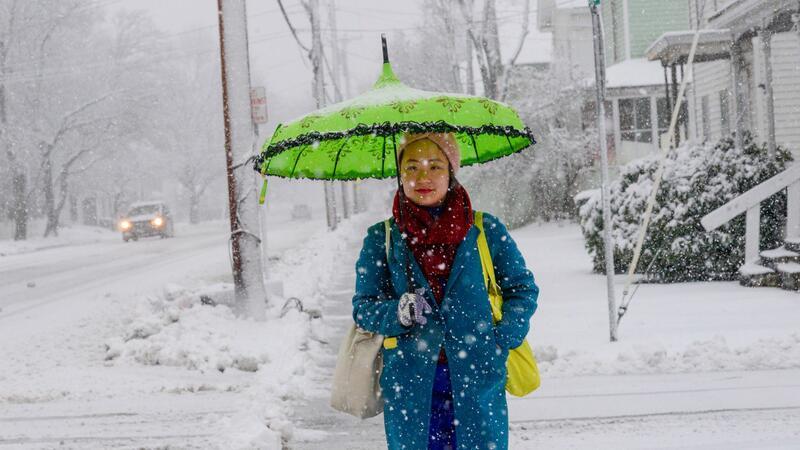 Eine Frau schützt sich in Bellows Falls in Vermont mit einem Schirm vor den Schneeflocken.