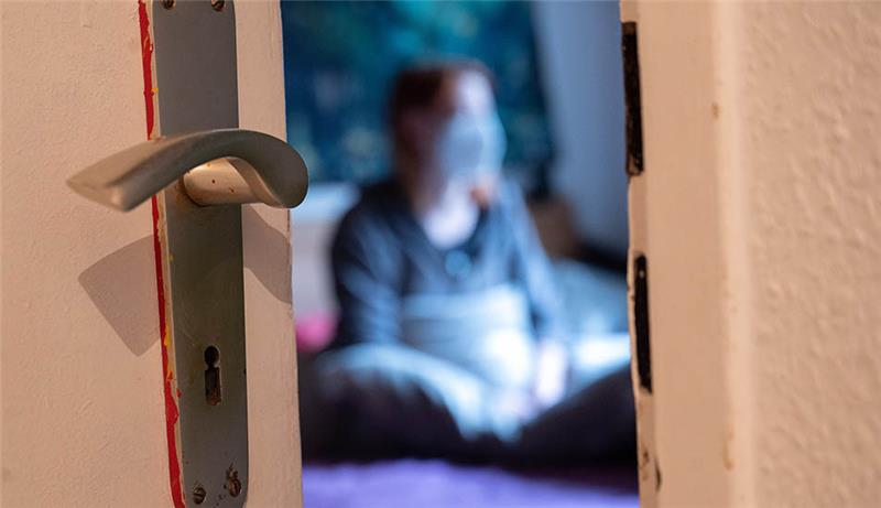 Weiter geteiltes Echo auf Ende der Corona-Isolationspflicht Eine Frau sitzt während der Isolation nach einem positiven Corona-PCR-Test auf ihrem Bett. Schleswig-Holstein schafft als erstes Bundesland im Norden die Absonderungspflicht für Corona-Infizierte ab. Foto: Sebastian Gollnow/dpa