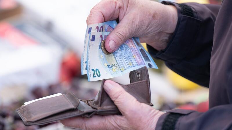 Inflation fällt auf 2,2 Prozent - Eine Frau sortiert auf einem Wochenmarkt das Wechselgeld für ihre Einkäufe in ein Portemonnaie.