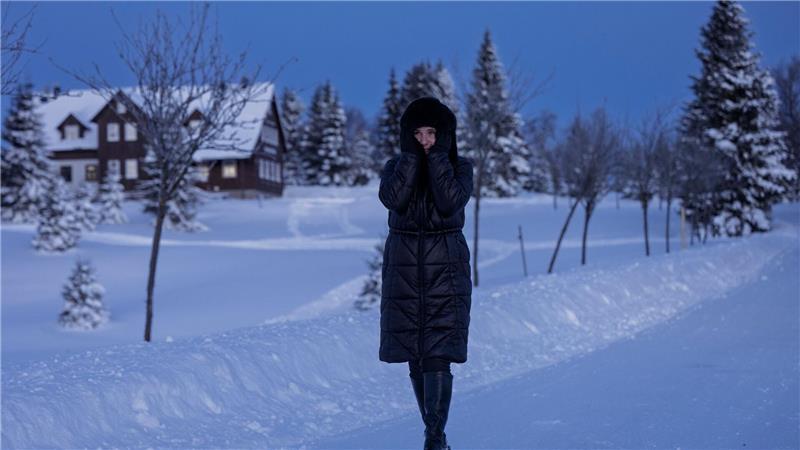 Eine Frau spaziert durch eine verschneite Landschaft in Tschechien.