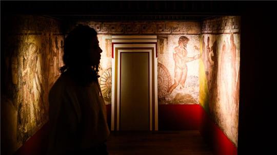 Eine Frau steht in der Ausstellung „Gründer Roms. Etruskische Schätze aus der Villa Giulia“.