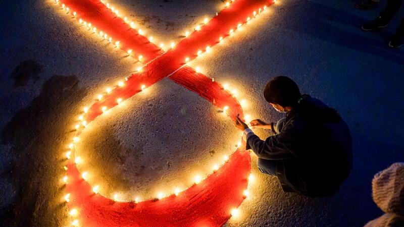 Welt-Aids-Konferenz: Millionen Infizierte ohne Therapie Eine Frau stellt Kerzen auf, die eine rote Schleife formen - ein weltweit anerkanntes Symbol für die Solidarität mit HIV-Infizierten.