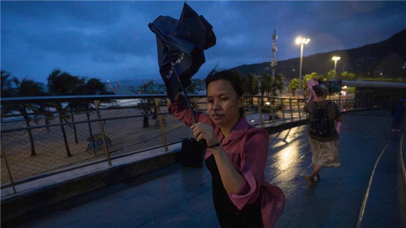 Bilder des Tages Eine Frau versucht, nach dem Super-Taifun Ragasa in Shenzhen in der südchinesischen Provinz Guangdong einen Regenschirm im Wind zu öffnen.