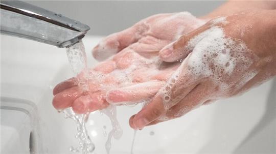 Eine Frau wäscht sich die Hände.
