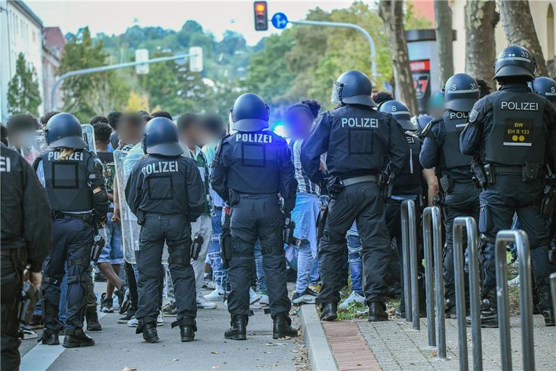 Eine Gruppe von Menschen wird nach Ausschreitungen bei einer Eritrea-Veranstaltung von Polizeikräften eingekesselt.