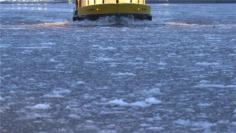 Eine Hafenfähre hat auf der Elbe leichtes Spiel: es treiben nur kleinere Eisschollen auf dem Fluss. 