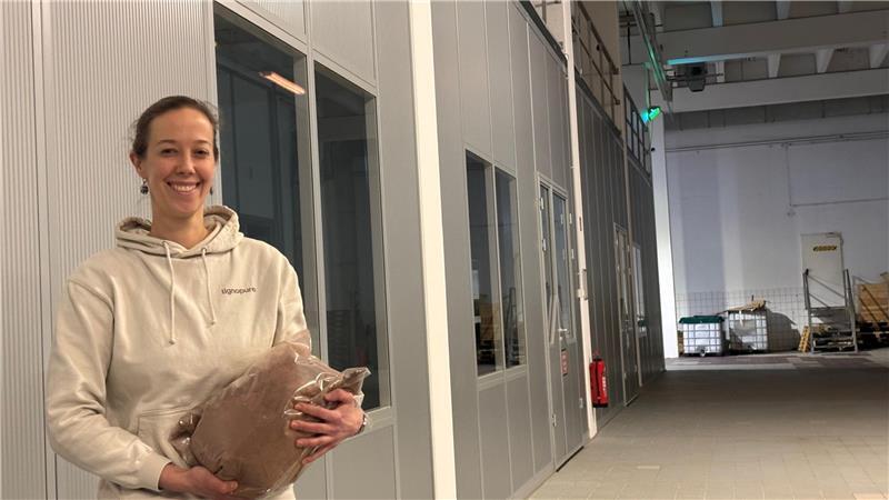 Eine Halle (links) in der Halle hat das Technologieunternehmen Lignopure im Sirius Business Park in Buxtehude errichtet. Die Bioverfahrensingenieurin Dr. Wienke Reynolds hält einen Sack Ligninpulver in den Händen.