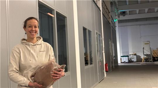 Eine Halle (links) in der Halle hat das Technologieunternehmen Lignopure im Sirius Business Park in Buxtehude errichtet. Die Bioverfahrensingenieurin Dr. Wienke Reynolds hält einen Sack Ligninpulver in den Händen.