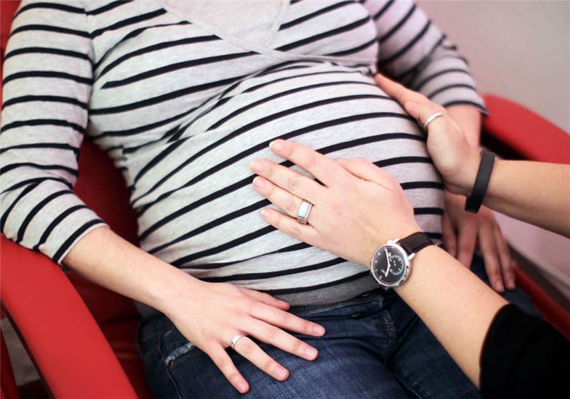 Eine Hebamme tastet den Bauch einer Schwangeren ab. Foto: Fredrik Von Erichsen/dpa
