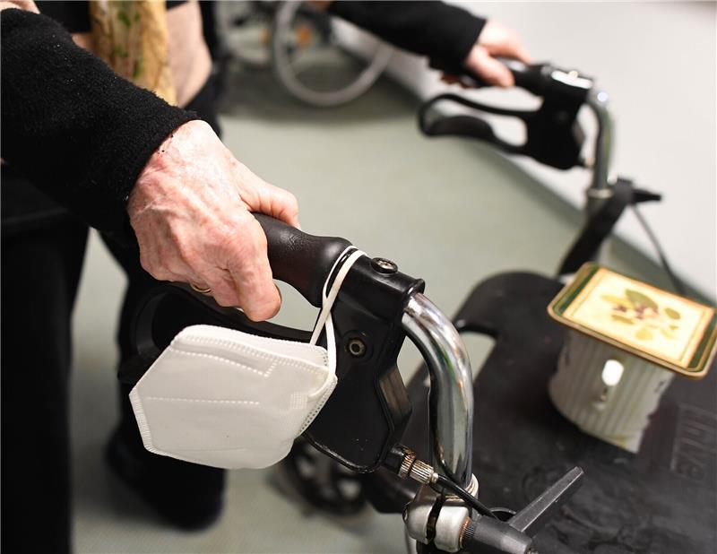 Senioren im Alltag begleiten und unterstützen – Neuer Kursus beginnt in Hammah Eine Heimbewohnerin schiebt ihren Rollator mit FFP-2 Maske durch einen Gang in einem Altersheim. Foto: Angelika Warmuth/dpa