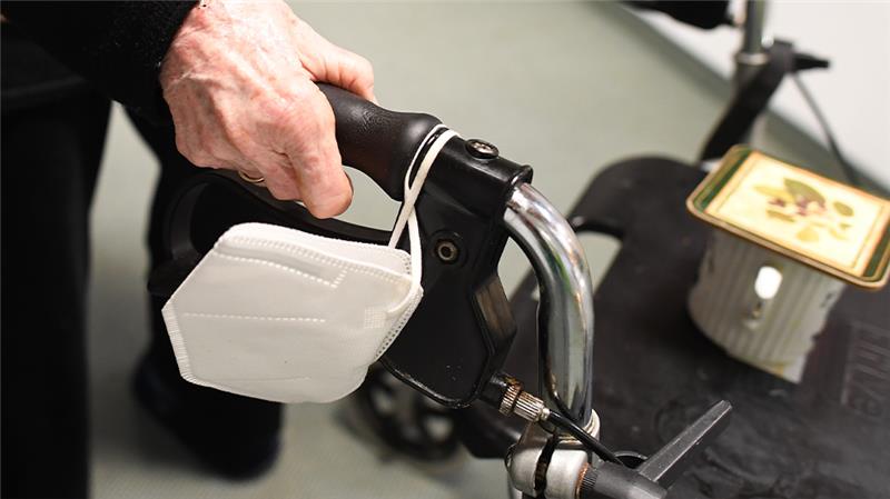 Niedersachsen sieht Maskenpflicht in Heimen locker Eine Heimbewohnerin schiebt ihren Rollator mit FFP-2 Maske durch einen Gang in einem Altersheim. Foto: Angelika Warmuth/dpa